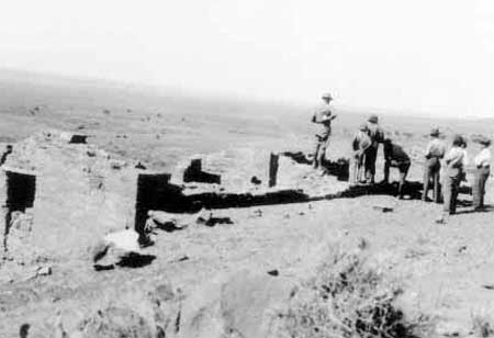 Mather standing on wall of west cabin with the
Heatons